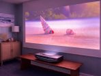 Proyektor Ultra Short Throw Proyektor Ultra Short Throw menghadirkan pengalaman menonton hingga 100 inci hanya dari jarak beberapa sentimeter dari dinding, menjadikannya alternatif TV modern dengan kualitas sinematik dan desain minimalis untuk ruang keluarga.