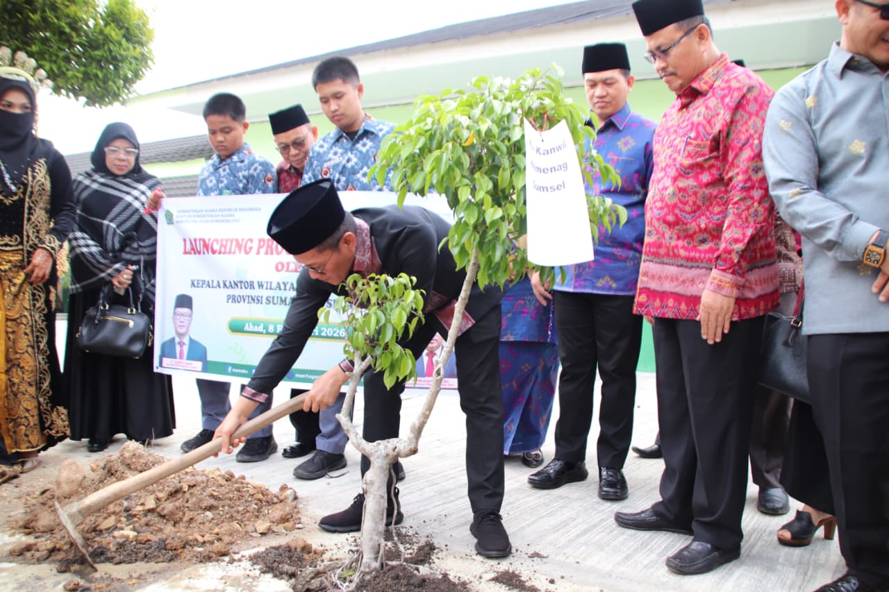 Kakanwil Kemenag Sumsel Syafitri Irwan menanam bibit pohon di lingkungan MAN 1 OKU, Minggu (8/2/2026), sebagai wujud komitmen gerakan Ekoteologi dalam menjaga kelestarian lingkungan.