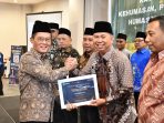 Kakanwil Kanwil Kemenag Sumsel Syafitri Irwan menyerahkan piagam penghargaan kepada perwakilan Satker pada puncak Anugerah Humas Award 2026 di Hotel Amaris Palembang, Kamis (12/2/2026).