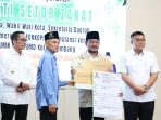 Wali Kota Ratu Dewa didampingi Wakil Walikota Prima Salam menyerahkan bukti setor Zakat Maal kepada Badan Amil Zakat Nasional Kota Palembang dalam rangkaian Gerakan Ramadan Berkah 2026 sebagai komitmen penguatan ekonomi umat di Kota Palembang.