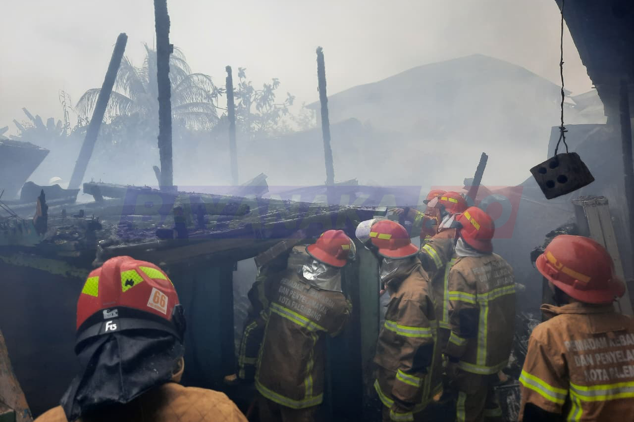 Petugas damkar berjibaku memadamkan api yang melalap tiga rumah semipermanen di Lorong Manggar, Kelurahan Lawang Kidul, Palembang, Minggu (1/3/2026) siang.